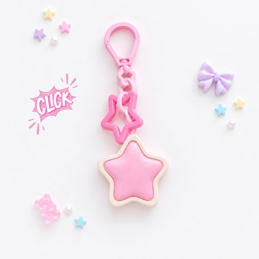 Clicker Étoile Kawaii Pop Studio : étoile rose bombée dans un contour crème, avec mousqueton rose et petite chaîne à maillon étoile